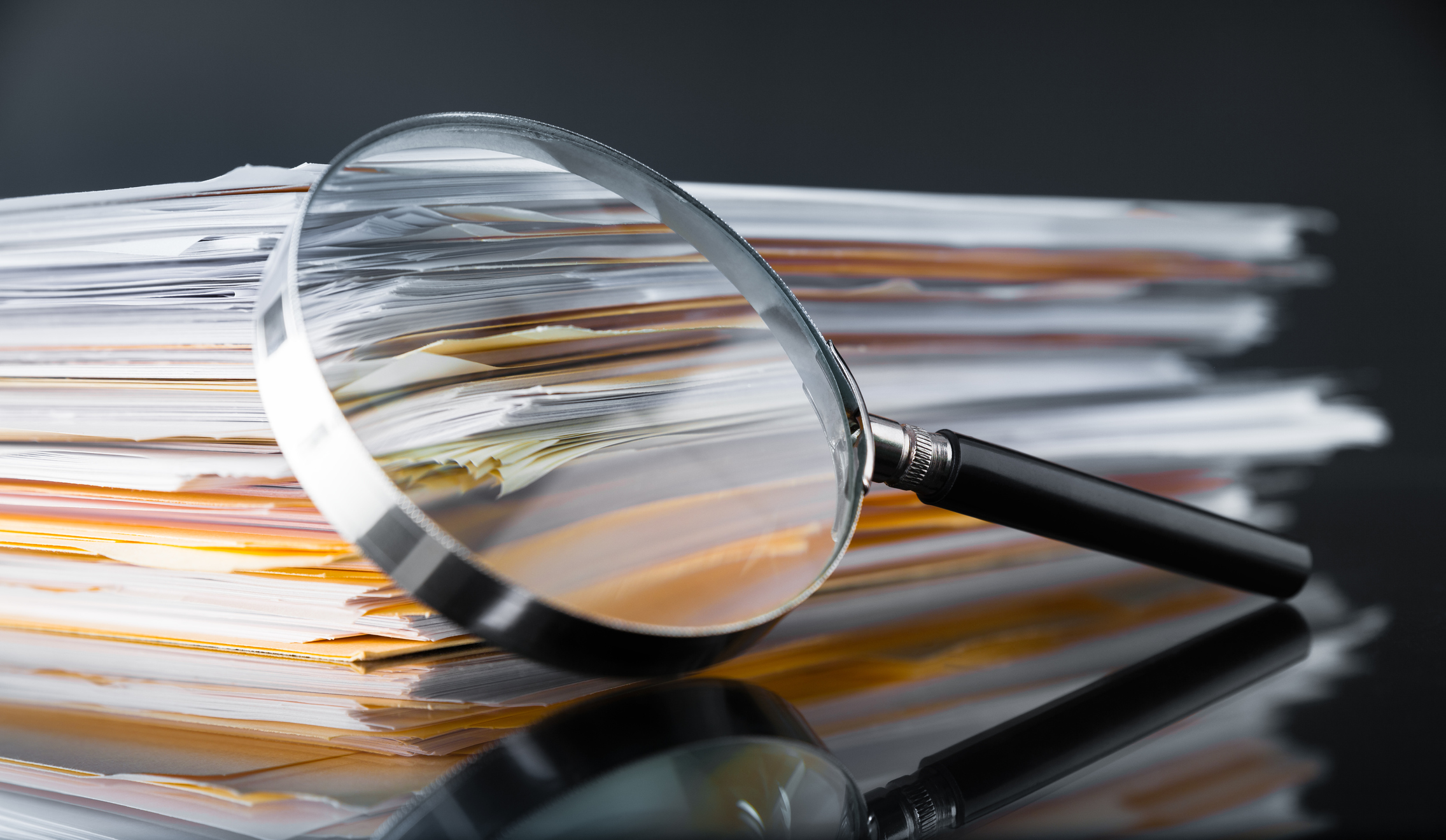 Magnifier leaning against a stack of documents